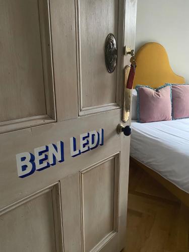 a door with the words ben leed on it next to a bed at Ben A'an House in Callander