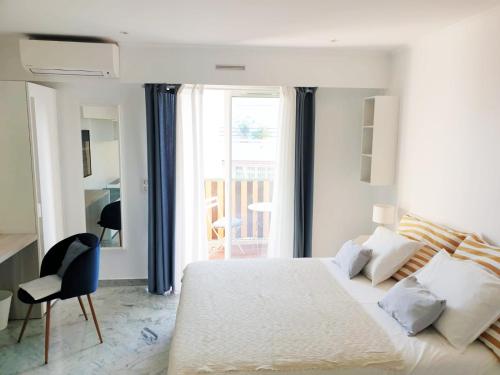 a white bedroom with a bed and a window at Beautiful T1 with sea view in Nice