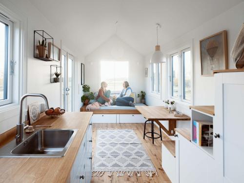 two people sitting on a bench in a kitchen at Camp Saltstraumen-Elvegård in Bodø