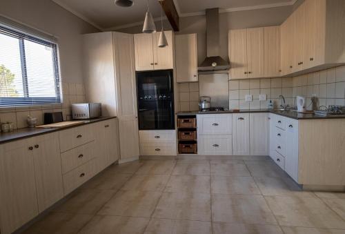 a large kitchen with white cabinets and appliances at SERENE VIEW, simply beautiful accommodation in Groot Brak Rivier