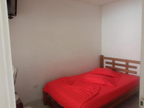 a bedroom with a red bed with red sheets at Hotel Panorama Neiva in Neiva
