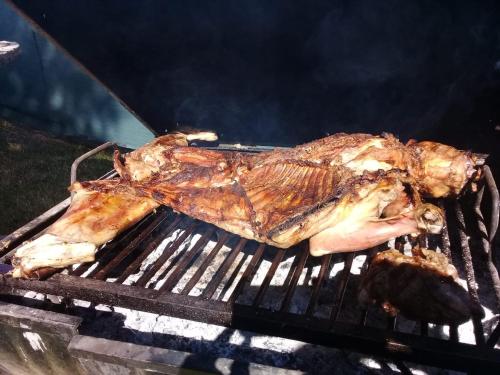 a piece of meat is cooking on a grill at Casa de Campo Finca La Superiora in La Consulta