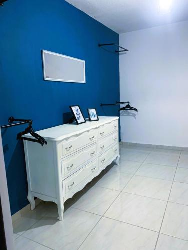 a room with a white dresser and a blue wall at Casa Real San Marcos A en Privada Zona Norte in Irapuato