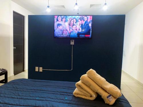 a bedroom with a tv on a blue wall at Casa Real San Marcos A en Privada Zona Norte in Irapuato