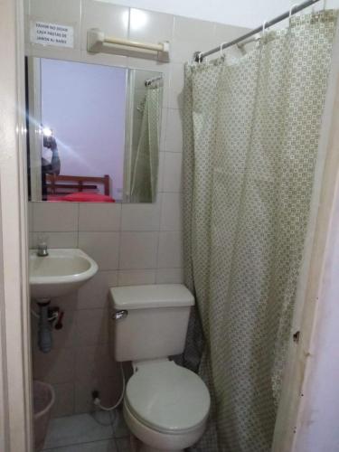 a bathroom with a toilet and a sink and a mirror at Hotel Panorama Neiva in Neiva