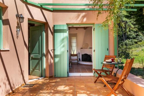 a patio with a green door and a table and chairs at Myrto's House at Agnontas in Agnontas