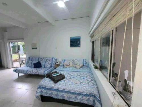 Jones Beach Haven Studio - Kiama Downs Beachside Escape في كياما: غرفة نوم بسرير كبير وأريكة