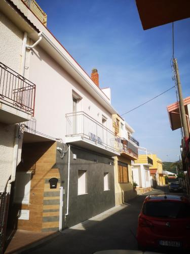 a building with two balconies and a car on a street at B&B Tonnarella Beach in Torre Forte