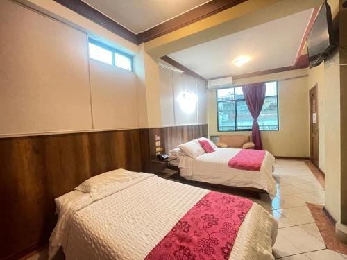 una camera d'albergo con due letti e una finestra di House Center a Milagro