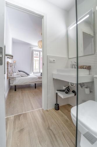 a white bathroom with a sink and a mirror at 32CaL QuEROL Boutique Puigmal in Puigcerdà