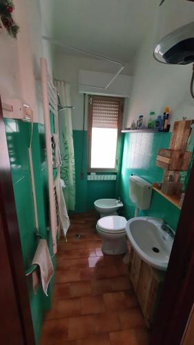 bagno verde con due servizi igienici e lavandino di Ambra a Palazzuolo sul Senio