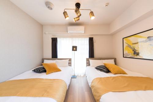 2 Einzelbetten in einem Zimmer mit Fenster in der Unterkunft SG RESIDENCE INN HAKATA - Vacation STAY 61970v in Fukuoka