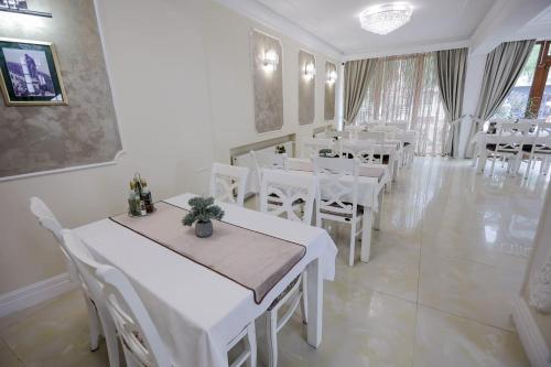 a dining room with white tables and white chairs at Pensiune Restaurant Select in Băile Herculane