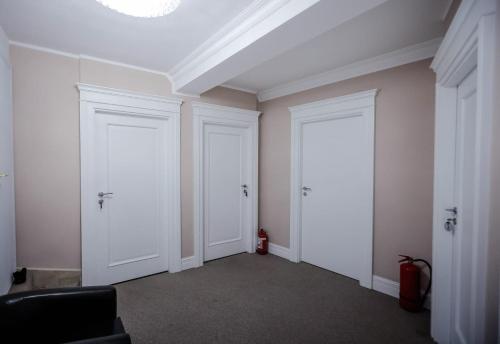 a hallway with two white doors in a room at Pensiune Restaurant Select in Băile Herculane