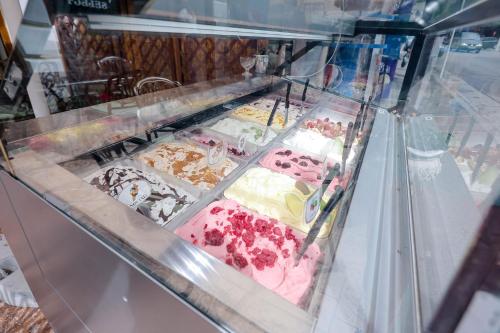 a display case filled with cakes and other desserts at Pensiune Restaurant Select in Băile Herculane