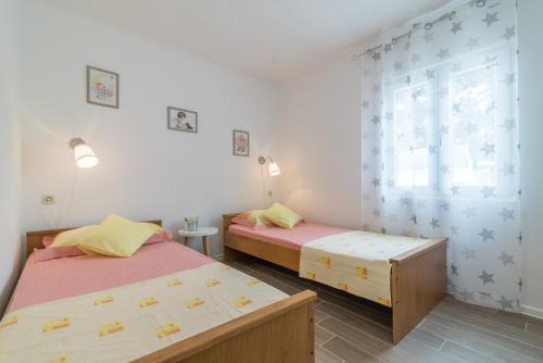 a bedroom with two beds and a window at Apartments Punta in Kruševo