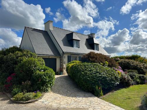 a house with a gray roof and some bushes at Les Camelias in Binic