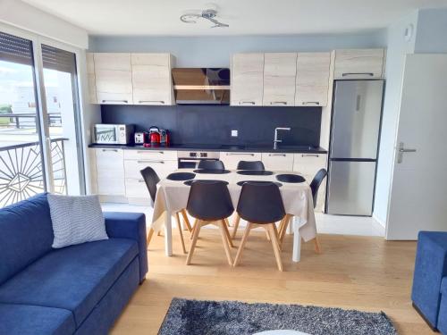 a kitchen with a blue couch and a table with chairs at BELQUIS in Chessy