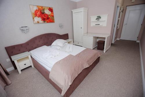 a small bedroom with a bed and a desk at Pensiune Restaurant Select in Băile Herculane