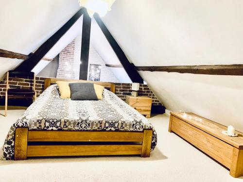 ein Schlafzimmer mit einem Bett im Dachgeschoss in der Unterkunft Villa SAINT CHRISTOPHE de FIRFOL in Firfol