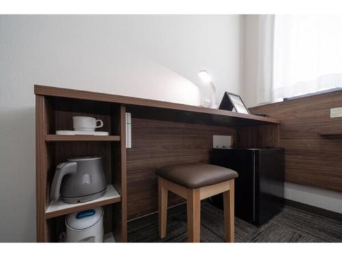 un tabouret assis sous une étagère à côté d'un four micro-ondes dans l'établissement R&B Hotel Sendai Higashiguchi - Vacation STAY 39923v, à Sendai