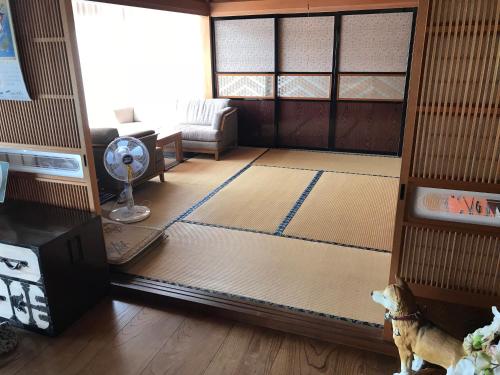 a living room with a dog standing in the middle of the room at 桃源舎 in Tamura