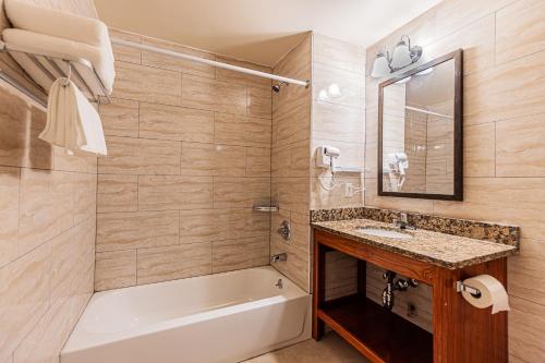 y baño con bañera, lavamanos y bañera tubermott. en Astoria Inn LaGuardia Hotel, en Steinway