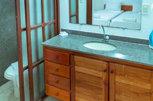 a bathroom with a sink and a mirror at Res Village do Bosque 16 in Porto Seguro