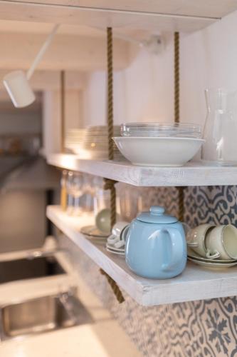 a shelf with dishes and a blue pot on it at Sea Pearl in Komiža