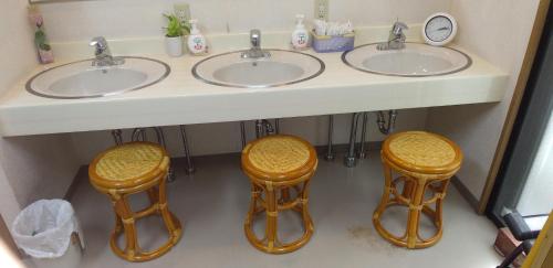 a bathroom with two sinks and two stools under it at INARIRYOKAN - Vacation STAY 47680v in Sayama