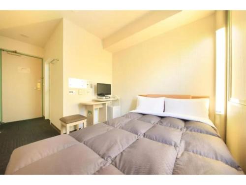 una camera da letto con un grande letto con cuscini di R&B Hotel Sendai Hirosedori Ekimae - Vacation STAY 39668v a Sendai
