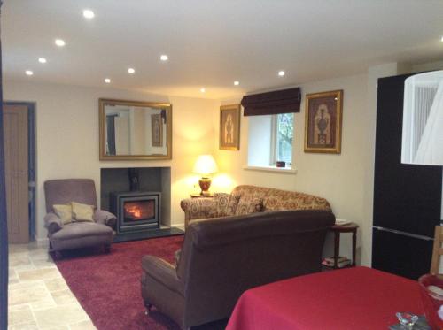 a living room with a couch and a chair and a fireplace at Best Beach 2025 "Little Haven" & The Hidden Gem in Haverfordwest