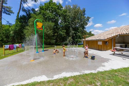 un grupo de niños jugando en un parque acuático en Tente Indiana Chênes - La Téouleyre en Saint-Julien-en-Born