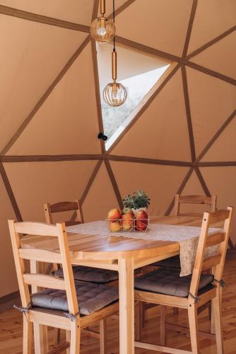 a wooden table and chairs in a tent at VasaRojaus Kupolai in Birštonas