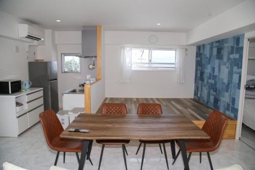 a kitchen and dining room with a wooden table and chairs at Guest room WES - Vacation STAY 54452v in Uruma