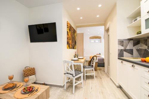 a kitchen and dining room with a table and a television at Fontana Di Corfu 4 in Corfu Town