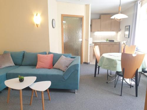 a living room with a blue couch and a table at Ferienwohnung Weißes Ross in Pirna