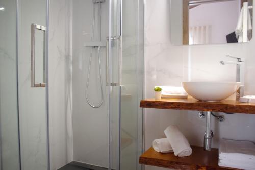 a bathroom with a glass shower and a sink at Helena's Family House in Pinhão