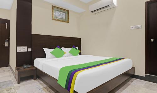 um quarto com uma grande cama branca e um cobertor colorido em SY Elite Residency em Hyderabad