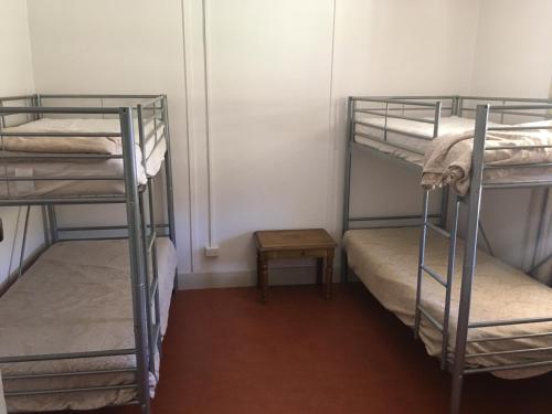 a room with three bunk beds and a table at Old Homestead - The Dutchmans Stern Conservation Park in Quorn
