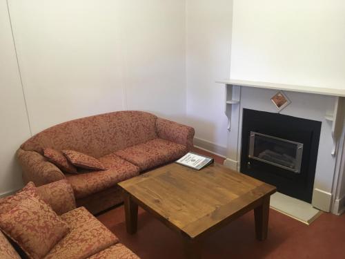 ein Wohnzimmer mit einem Sofa und einem Kamin in der Unterkunft Old Homestead - The Dutchmans Stern Conservation Park in Quorn