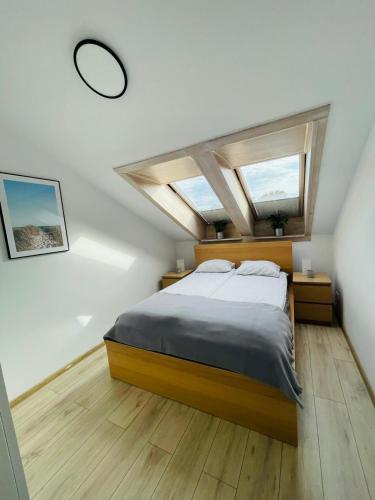 een slaapkamer met een bed en 2 ramen bij Apartament z widokiem na wydmę in Ustka