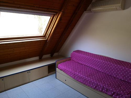 a purple bed in a room with a window at Appartamento Di Bella simil villetta panoramicissimo in Letojanni