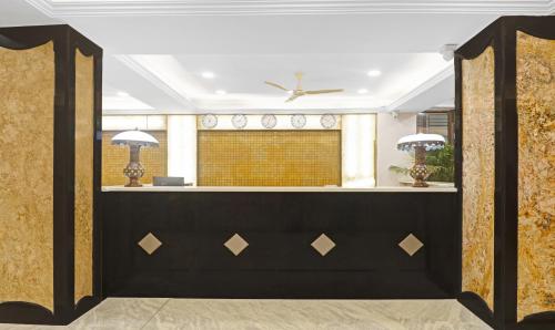 eine Lobby mit einem Empfang in Schwarz und Gold in der Unterkunft SY Elite Residency in Hyderabad
