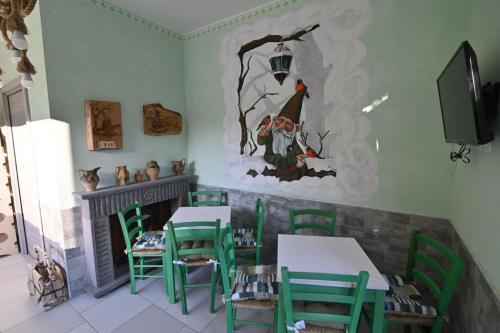 a dining room with green chairs and a fireplace at Agriturismo le Fontane - Lago di Bolsena in Grotte di Castro