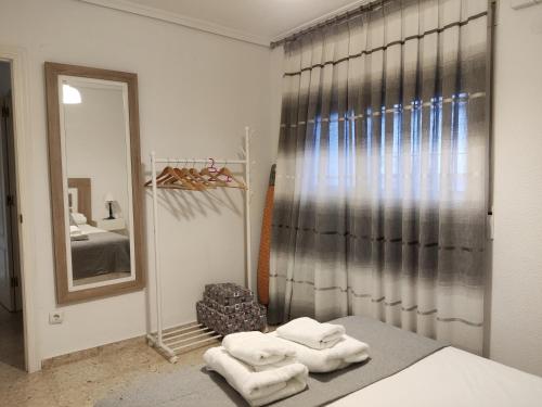 een slaapkamer met een spiegel en handdoeken op een bed bij Nuevo Sueño del Alcazar in Córdoba