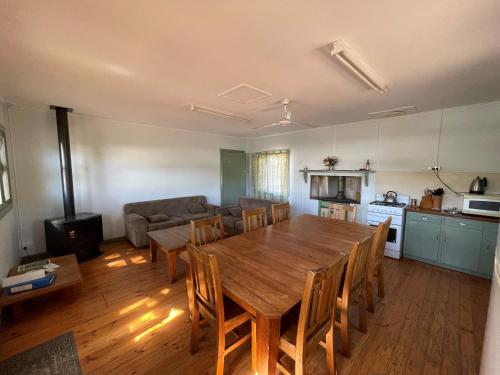 a living room with a wooden table and a couch at Shearers Quarters - The Dutchmans Stern Conservation Park in Quorn