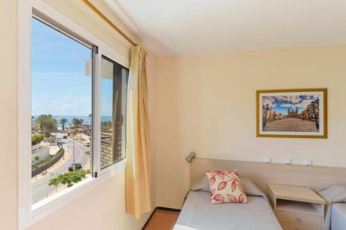 a bedroom with a bed and a window at Apartamentos las Góndolas in Playa del Ingles