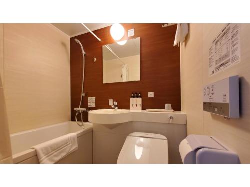 La salle de bains est pourvue de toilettes, d'un lavabo et d'un miroir. dans l'établissement ｂｕｓｉｎｅｓｓ&ａｃｔｉｖｉｔｙ ｃｈａｎｖｒｅ - Vacation STAY 64321v, à Tochigi