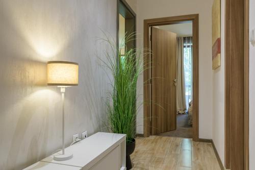 a bathroom with a sink and a lamp and a plant at МareliS Luxe Port Apartment in Varna City